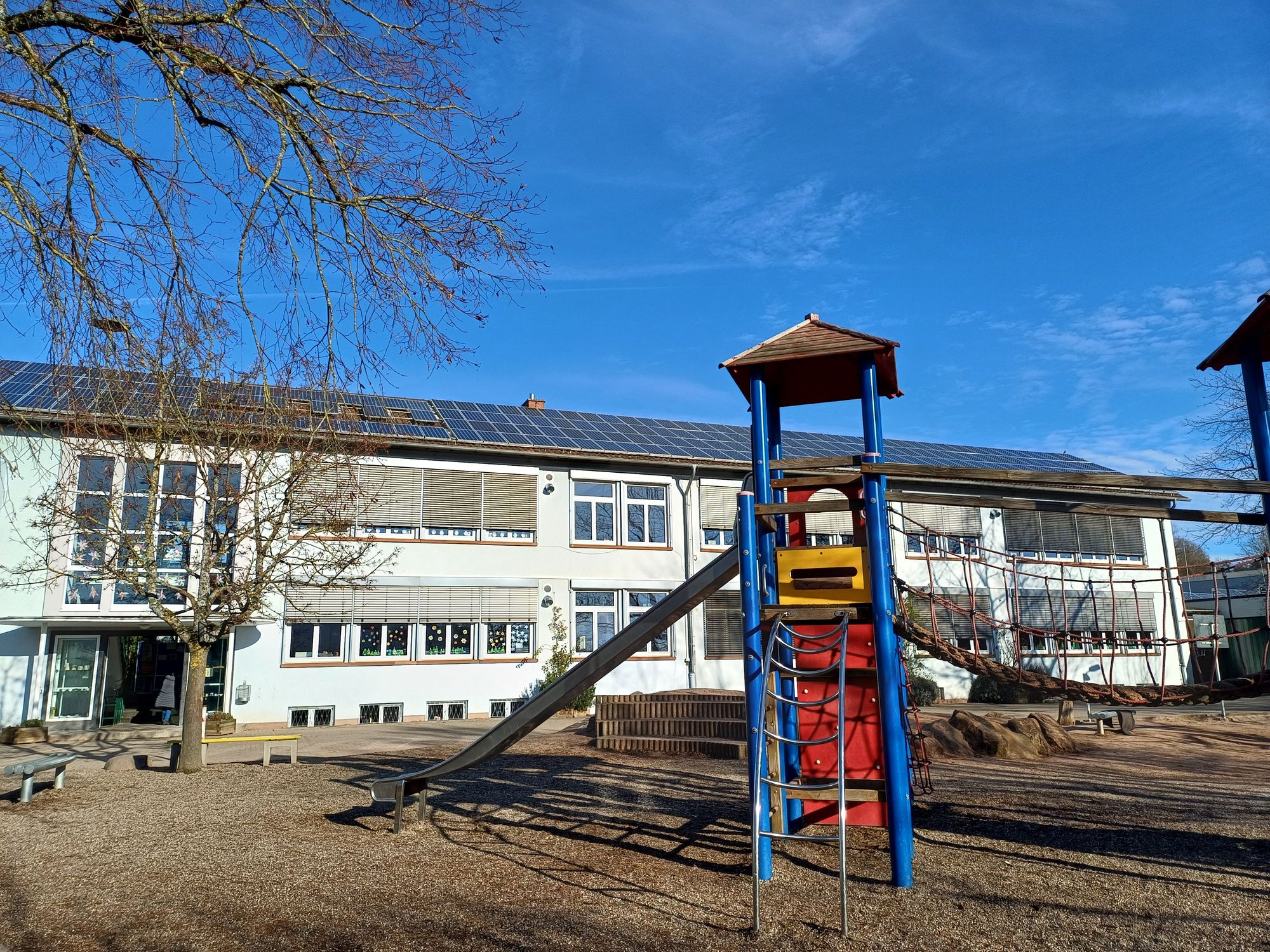 Schulgebäude mit Spielturm